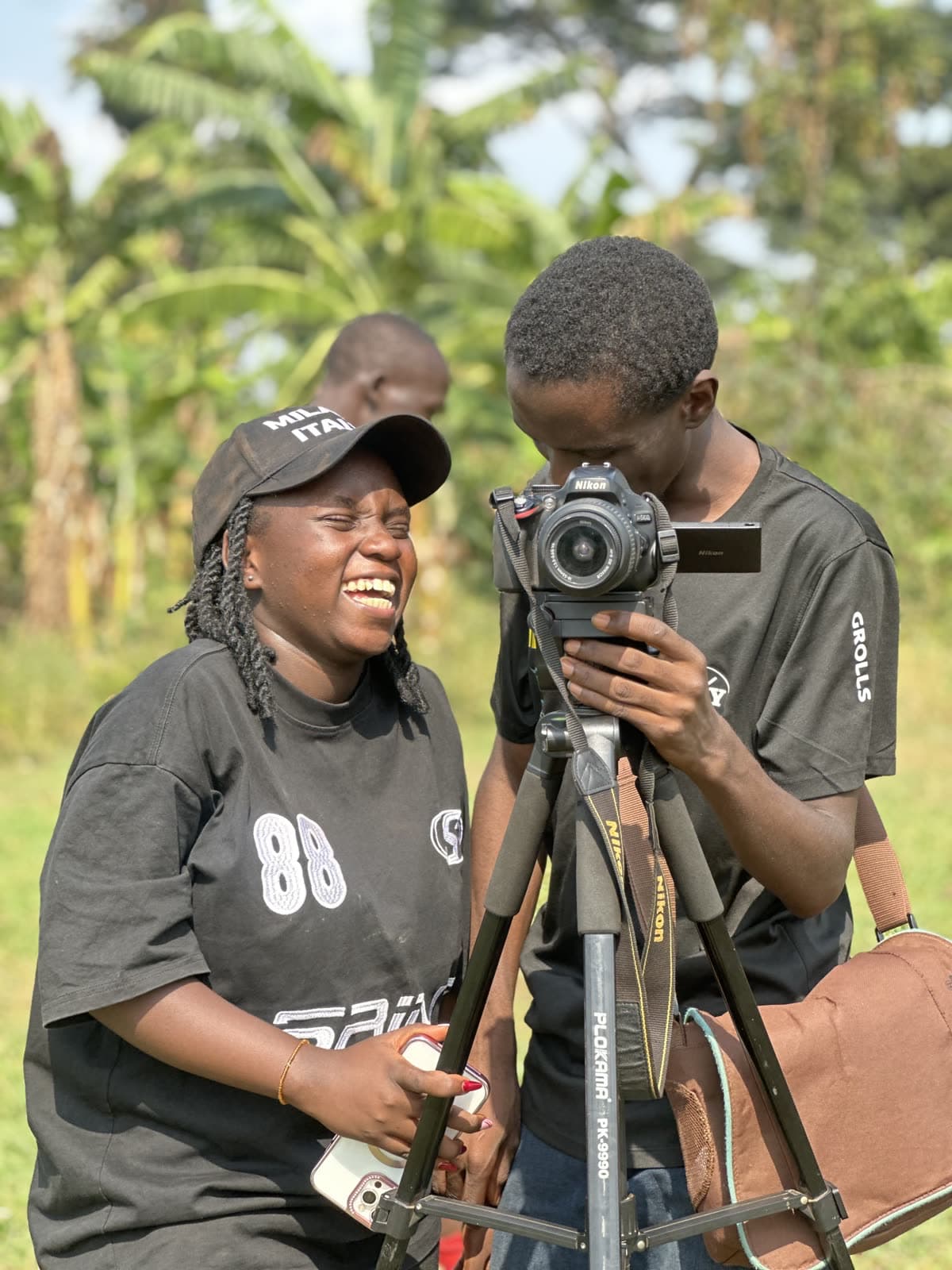 Two young Ugandan entrepreneurs working together with camera equipment